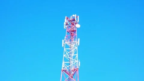 View of a cell tower against a clear blue sky on a sunny day Stock Footage 328116877