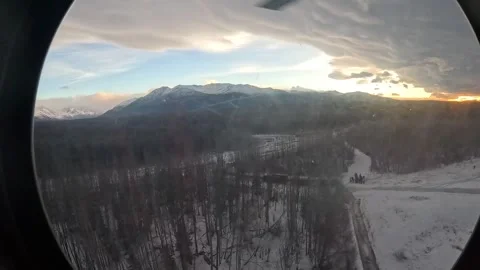 A view from a CH-47 Chinook of the Alaskan snow-covered landscape at sunset Stock Footage 295350193