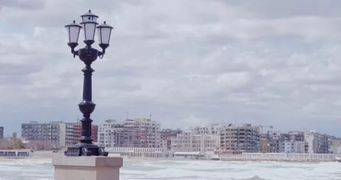 View of a characteristic lamppost on the Bari seafront with the rough sea bre Vídeo Stock 152582789