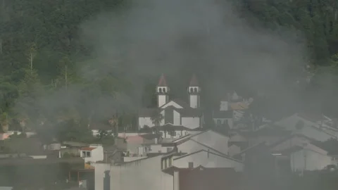 View of a charming church with two distinct red-roofed spires rising above the 库存影片 335726138