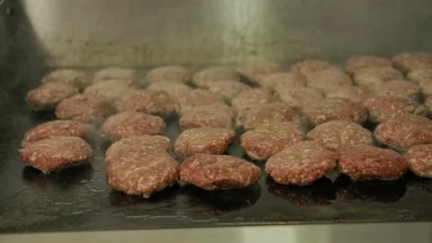 View of a chef preparing meat for hamburgers and hot dogs in the food truck Stock Footage 202077773