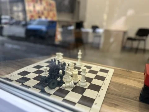View of the chess on the table through the window glass. The concept of Foto stock