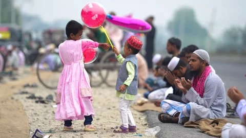 View of children with balloons and men praying during Eid, Bangladesh. Video stock 334992007