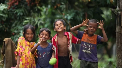 View of children laughing and playing in an orchard, Bangladesh. Video stock 335584320