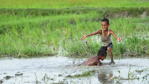 View of children playing in a muddy field in Bogura, Bangladesh. Video stock 335584139