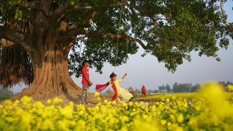 View of children playing under a banyan tree, Bangladesh. 動画素材 335583711