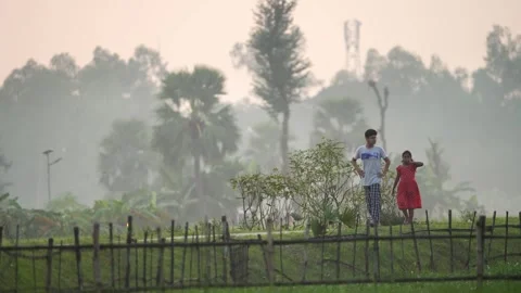 View of children walking behind a bamboo fence in Bogura, Bangladesh. Video stock 335586065