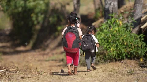 View of children walking on a rural path with backpacks, Nepal. Video stock 335467832