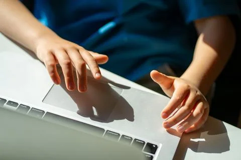 View of children's hands doing homework on laptop at home, distant learning Stock Photos