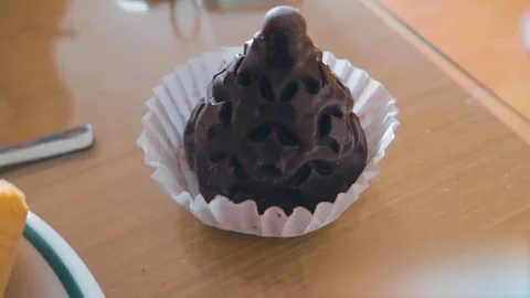 A view of a chocolate cup cake and breads on the dinning table of Stock Footage 123882807