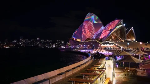 View from Circular Quay around to crowded Sydney Opera House and restaurants Stock Footage 128401329
