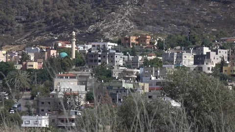 View of City on Cliffside Through Waving Grass Stock Footage 78551917