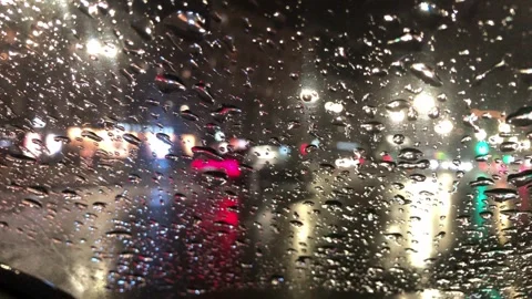 View of the city lights at night and cars through a window with raindrops Stock-Footage 317871320