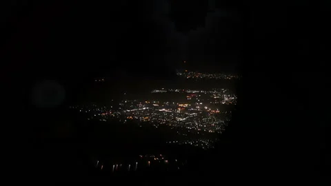 View of city lights through an airplane porthole Stock Footage 120511397