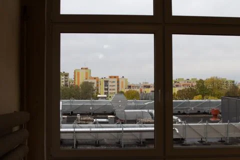 View of city rooftops from a building window on a cloudy day in autumn Stock Photos