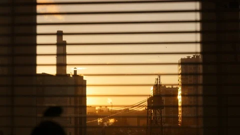 View of city through opening and closing blinds at sunrise Vídeo Stock 128074782