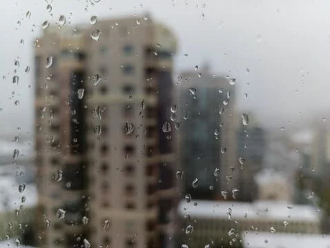 A view of a city through a window with raindrops on it Stock-Fotos