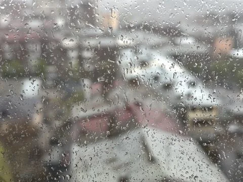View of the city through the window on a rainy day with dark clouds Stock Photos