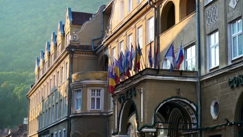 View of a classic building in old town centre with multiple flags on it in Stock Footage 250363440
