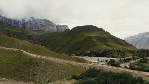 A view of clear mountain lake of irregular shape located between green hills Stock Footage 161077284