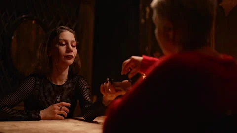View from client shoulder of mysterious fortune teller shuffling tarot cards and Stock Footage 275204396