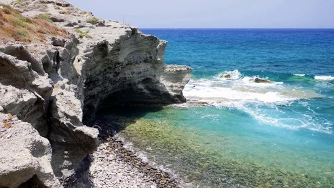 View of the cliff into the crystal clear azure sea near Papafragas beach. Video stock 82302959