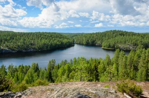 A view from the cliff over forest and lake in Finland. Stock Photos
