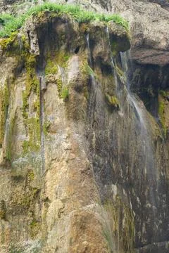 View of the cliff with water moss under the Chegem waterfall Stock Photos