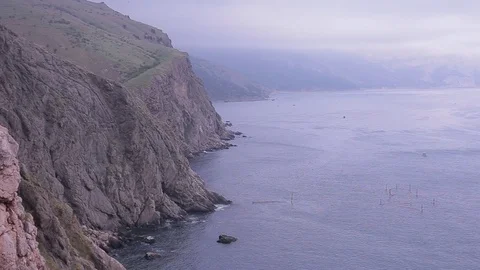 View of the cliffs of the sea and mountains in the fog. Stock Footage 76251765