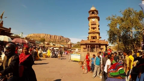 View on clock tower and mehrangarh fort marketplace many people blue sky timelap Stock Footage 89609409