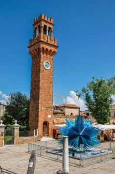 View of clock tower made of bricks and a star shape glass sculpture at Murano Stock Photos