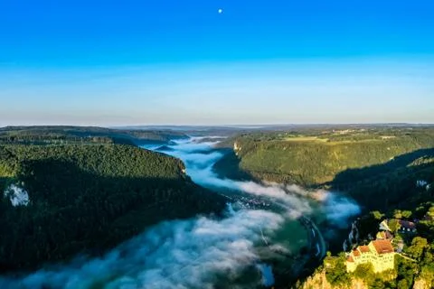 View of cloud-covered Danube valley from Beuron; Monastery on green hill Stock Photos