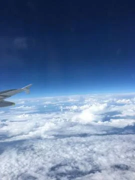 A view of the clouds from above in flight by plane from the porthole Stock Photos