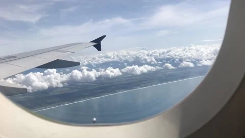 A view of the clouds above the sea from the window of an airplane. Stock Footage 234080955