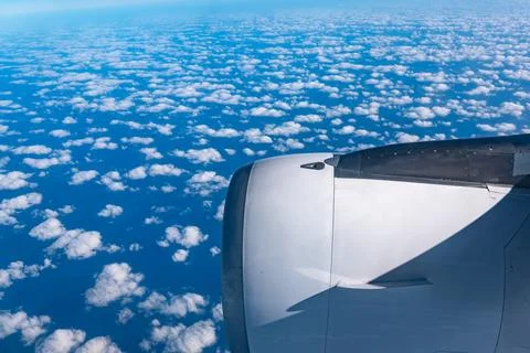 View of the clouds and blue sky from an airplane window. Stock Photos