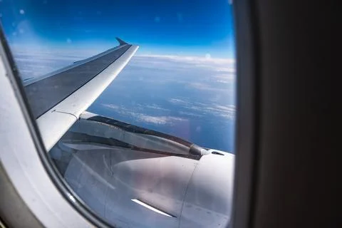 View of the clouds and blue sky from an airplane window. Stock Photos