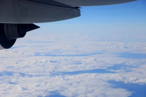 View of clouds and blue sky from an airplane window during flight Stock Photos