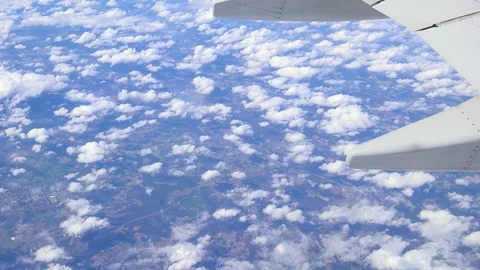 A view of clouds and the ground from an airplane with wing in shot. Stock Footage 86530358