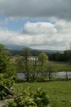 View of clouds, green fields and trees in Scotland Foto stock