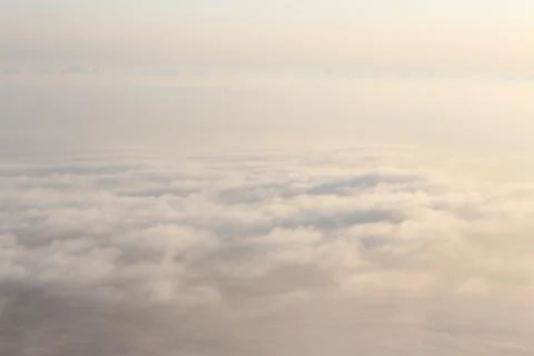 View of clouds from plane in beams of the sunset sun Stock Photos