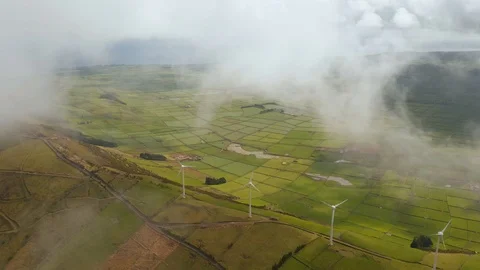 View from clouds on windmill farm on the ridge abovу green valley. Aerial of Stock Footage 121270716