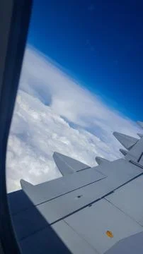 View of the clouds from the window. airplane wing on the background of blue sky Stock Photos