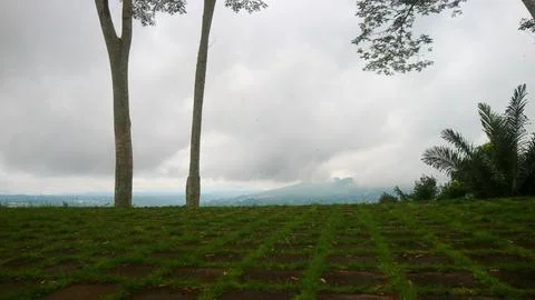 The view of the cloudy sky, trees, mountains and houses was photographed from Stock Photos
