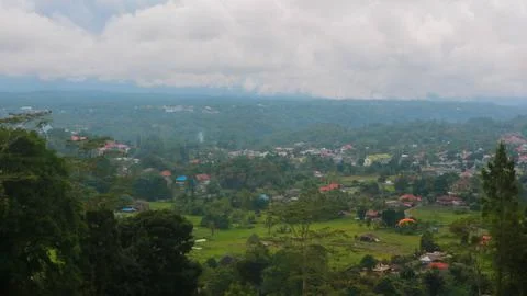 The view of the cloudy sky, trees, mountains and houses was photographed from Stock Photos