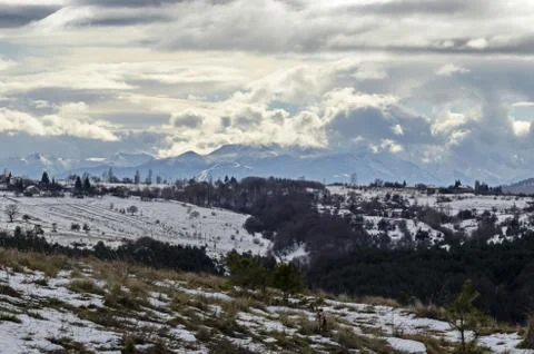 View of cloudy sky, winter mountain, residential district  and forest Stock Photos