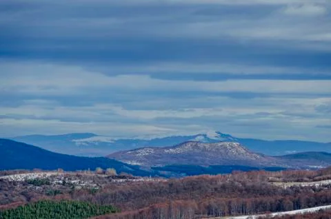 View of cloudy sky, winter mountain  and forest Stock Photos