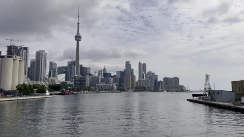 View of the CN Tower and buildings of Toronto behind the sea on a cloudy day in Vídeos de archivo 250084447