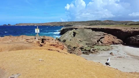 View of collapsed natural bridge at Arikok National Park with warning signs Stock Footage 329860367