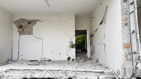 View of the collapsed wall room of a collapsed and cracked house Stock Footage 243093428