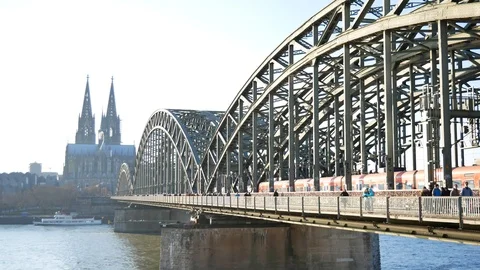 View of the Cologne Cathedral and bridge, with trains and pedestrians on a sunny Stock Footage 88630276